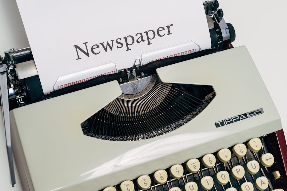 A close-up image of a classic vintage typewriter with a paper labeled 'Newspaper'.